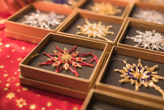 Handmade beaded Christmas ornaments in star shapes displayed in gift boxes